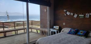 - une chambre avec un lit et un balcon donnant sur l'océan dans l'établissement Casa de diseño a pasos de la playa, WIFI banda ancha, teletrabajo, à Los Molles