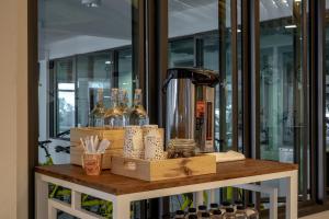 a table with a coffee maker and bottles of wine at Fine Bed Hotel in Nonthaburi