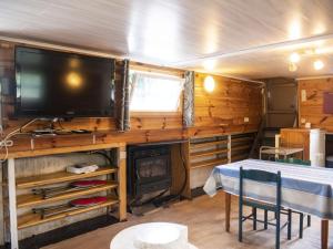 uma sala de estar com uma televisão, uma mesa e uma lareira em Comfy Houseboat in Florennes next to the Forest em Florennes
