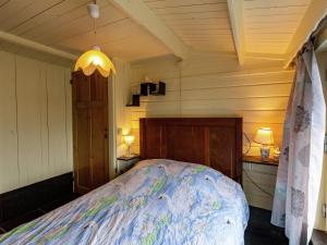 1 dormitorio con 1 cama en una habitación en Cozy Chalet with Private Garden near Lake in Westouter en Reningelst