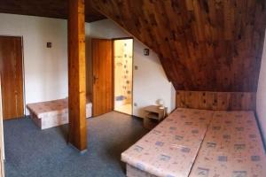 sypialnia z 2 łóżkami i drewnianym sufitem w obiekcie Apartment Rokytnice nad Jizerou 6 w mieście Hranice