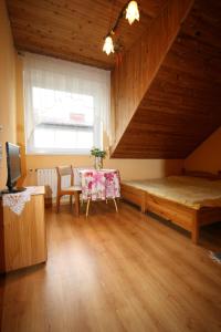 um quarto com uma mesa, uma cama e uma janela em Pokoje Klaudia em Darłowo