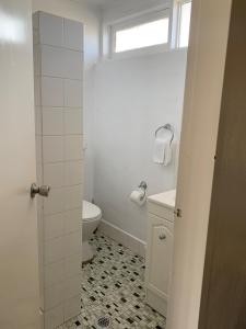 a white bathroom with a toilet and a sink at Allambie Motel in Condobolin
