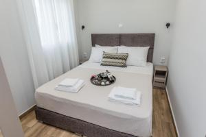 Una cama blanca con una bandeja de comida. en Raise Athens Metro Apartments en Atenas