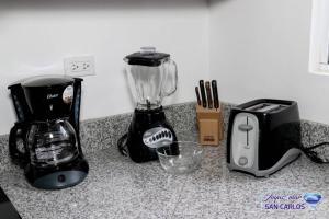 a kitchen counter with a blender and a toaster at Departamento Turquesa 3 joyas de mar San Carlos in San Carlos