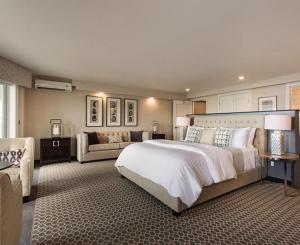 a large bedroom with a large bed and a couch at Fathoms Hotel & Marina in Port Washington