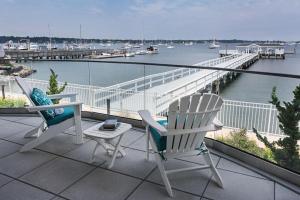 two chairs and a table on a balcony overlooking a harbor at Fathoms Hotel & Marina in Port Washington