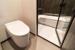 a bathroom with a toilet and a bath tub at Goi Grand Hotel in Ichihara