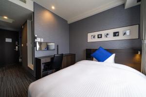 a hotel room with a bed and a desk at Goi Grand Hotel in Ichihara