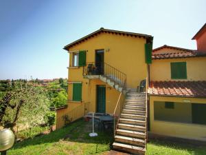 西恩納的住宿－Comfortable Mansion in Siena with Swimming Pool，黄色的房子,有楼梯通往