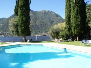 a swimming pool with trees and mountains in the background at Belvilla by OYO La Cava D in Pognana Lario