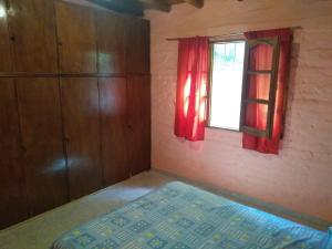 1 dormitorio con cama y ventana en Hospedaje Cabaña Lemos TUNUYAN en Tunuyán