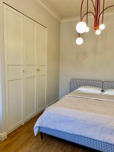 1 dormitorio con cama, armarios blancos y lámpara de araña en Little Home Centre en Irkutsk
