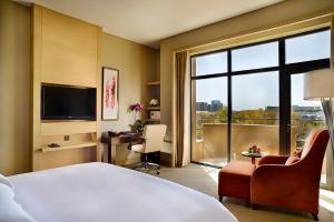 Cette chambre comprend un lit et une grande fenêtre. dans l'établissement Crowne Plaza Ordos, an IHG Hotel, à Ordos