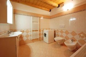 W łazience znajduje się umywalka i pralka. w obiekcie Appartamento Sissi w mieście Canazei