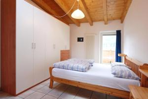 sypialnia z łóżkiem i oknem w obiekcie Appartamento Sissi w mieście Canazei