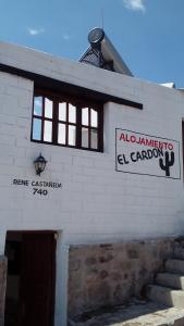 un edificio blanco con un cartel en el costado en Alojamiento El Cardon Tilcara en Tilcara