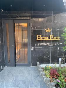einen Hoteleingang mit Tür und Schild darauf in der Unterkunft Hotel Emir in Tokio