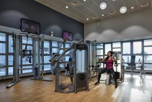 a woman sitting on a treadmill in a gym at Beachfront Property With Atlantis The Palm & Skydive View In Dubai Marina in Dubai