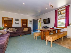 a living room with a couch and a table at The Station - Ohakune Holiday Home in Ohakune