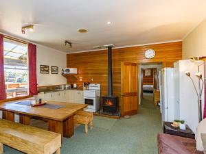 a kitchen and living room with a table and a stove at The Station - Ohakune Holiday Home in Ohakune