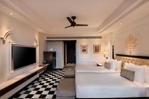 a hotel room with two beds and a flat screen tv at Aurika, Udaipur - Luxury by Lemon Tree Hotels in Udaipur