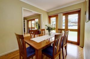 Un comedor con mesa y sillas de madera. en Retreat on Gleeson, en Forster 5 fotos más