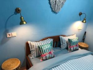 a blue bedroom with a bed with pillows on it at Padang Homestay in Padang