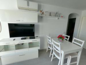 a white kitchen with a dining table and a television at Sonneland Canary Spa in San Bartolomé