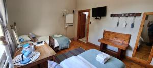 um quarto com duas camas e uma mesa e uma televisão em Bo Kamer Guesthouse em Ermelo