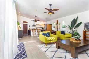 Una sala de estar con sillas amarillas y una mesa. en Kololia Living by Casago Kona - Your Private, Hawaiin Home with Pool, en Kailua-Kona