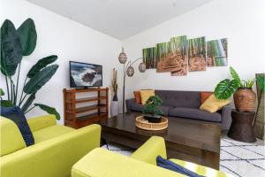Una sala de estar con sillas amarillas y un sofá. en Kololia Living by Casago Kona - Your Private, Hawaiin Home with Pool, en Kailua-Kona