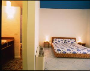a small bedroom with a bed and a bathroom at Morfeo33 in Lipari