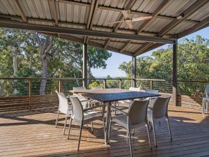 a wooden deck with a table and chairs on it at Ocean Mist House in Point Lookout