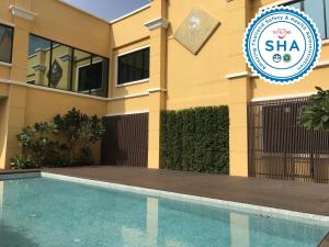 a villa with a swimming pool in front of a building at S Bangkok Hotel, Navamin in Ban Khi Sua