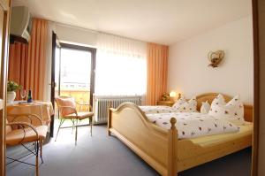 a bedroom with a large wooden bed and a window at Haus Iris in Bodenmais