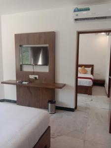 Habitación de hotel con cama y espejo en coral beach resort en Mahabalipuram