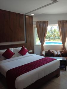 a bedroom with a large bed and a window at coral beach resort in Mahabalipuram