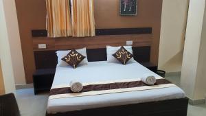 Un dormitorio con una cama con sábanas y almohadas blancas. en S4 Residency, en Chennai
