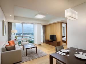 uma sala de estar com um sofá e uma mesa em LOTTE Hotel Serviced Apartment em Yangon