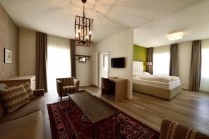 pokój hotelowy z łóżkiem i salonem w obiekcie Hotel Teutschhaus w mieście Cortina Sulla Strada Del Vino