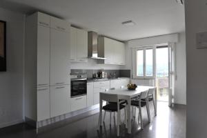 a kitchen with white cabinets and a table and chairs at Casa Marconi in Tuoro sul Trasimeno