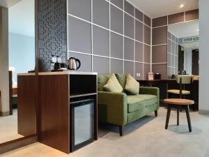 茂物的住宿－Swiss-Belinn Bogor，客厅配有绿色沙发和桌子