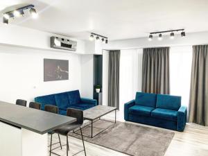 uma sala de estar com cadeiras azuis e uma mesa em WHITE VIBE em Cluj-Napoca