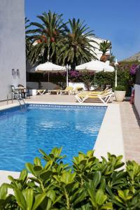 una piscina con sillas y sombrillas en Hotel Villa Singala, en Puerto Pollensa