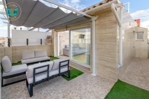 a patio with white chairs and an awning at Luxury Home With Terrace in Málaga