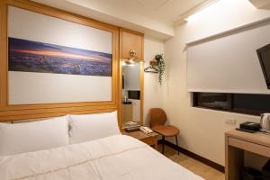 a hotel room with a bed and a television at 二川行旅 - HiRiver Hotel in Taichung