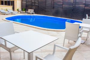 a pool with two tables and chairs and a table and chairsitures at MERINA HOTEL in Yaoundé