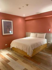 a bedroom with a large bed with red walls at Happy Inn in Taichung