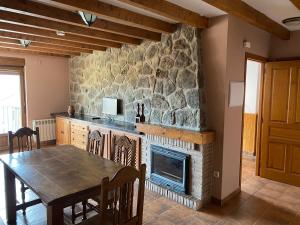 a dining room with a stone fireplace and a table at Mirasierra II Y III in Navarredonda de Gredos